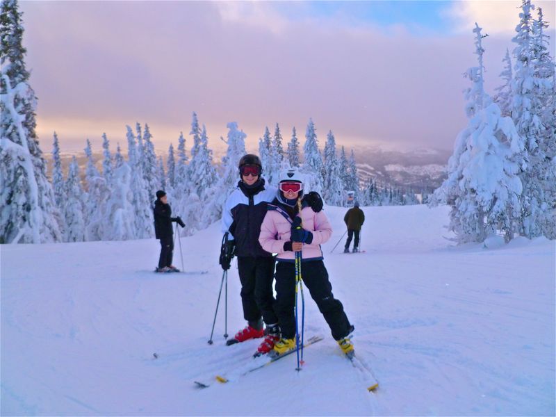 Daniel and Pernilla on skis on a snowy mountain slope among frosted trees