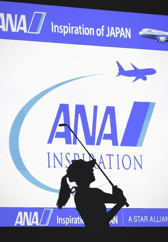 Silhouette of Pernilla Lindberg swinging in front of a large ANA Inspiration screen