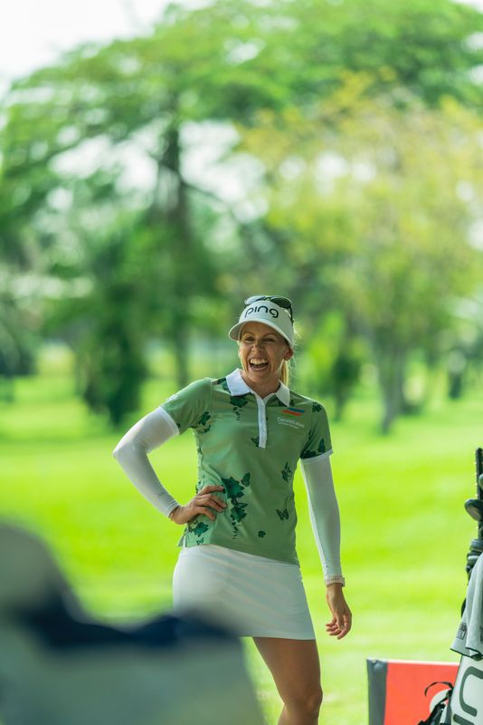 Pernilla Lindberg laughing on the practice range, club in hand